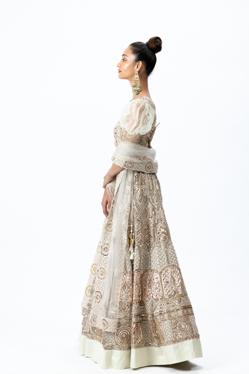 Beige Hand-embroidered Lehenga paired with Puff-sleeved Hand-embroidered Blouse and Hand-embroidered Dupatta with buttis