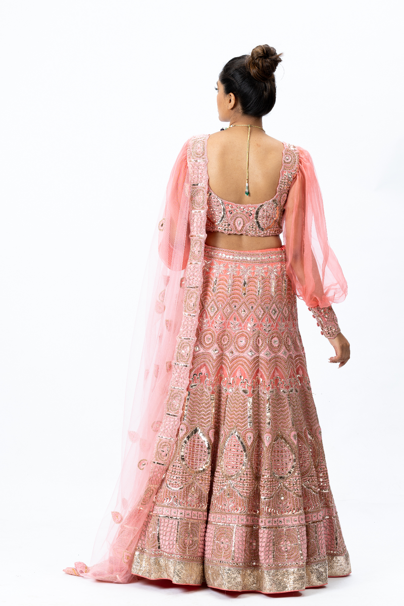 Coral Hand-embroidered Lehenga paired with Balloon-sleeved Hand-embroidered Blouse and Hand-embroidered Dupatta with buttis